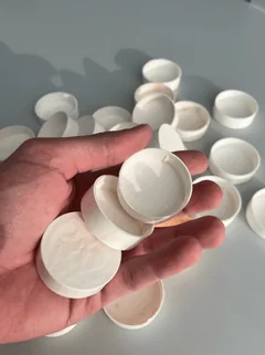 Avuçta beyaz biyoplastik kapaklar